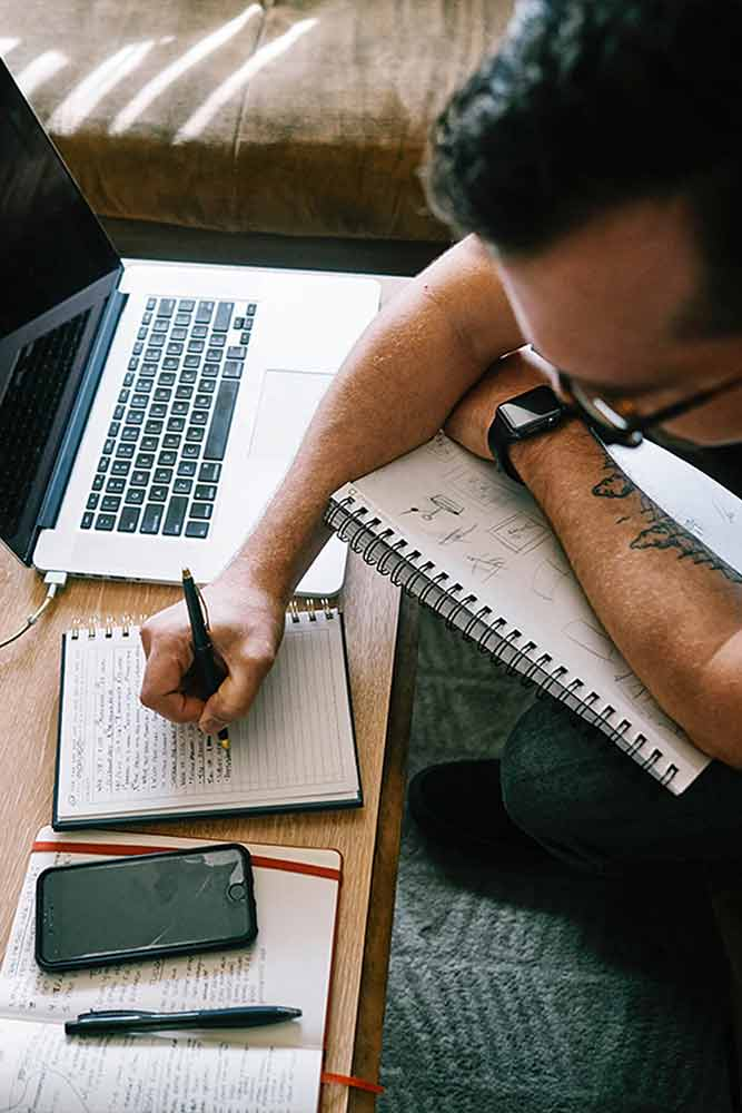 Strategist working with laptop and notebooks